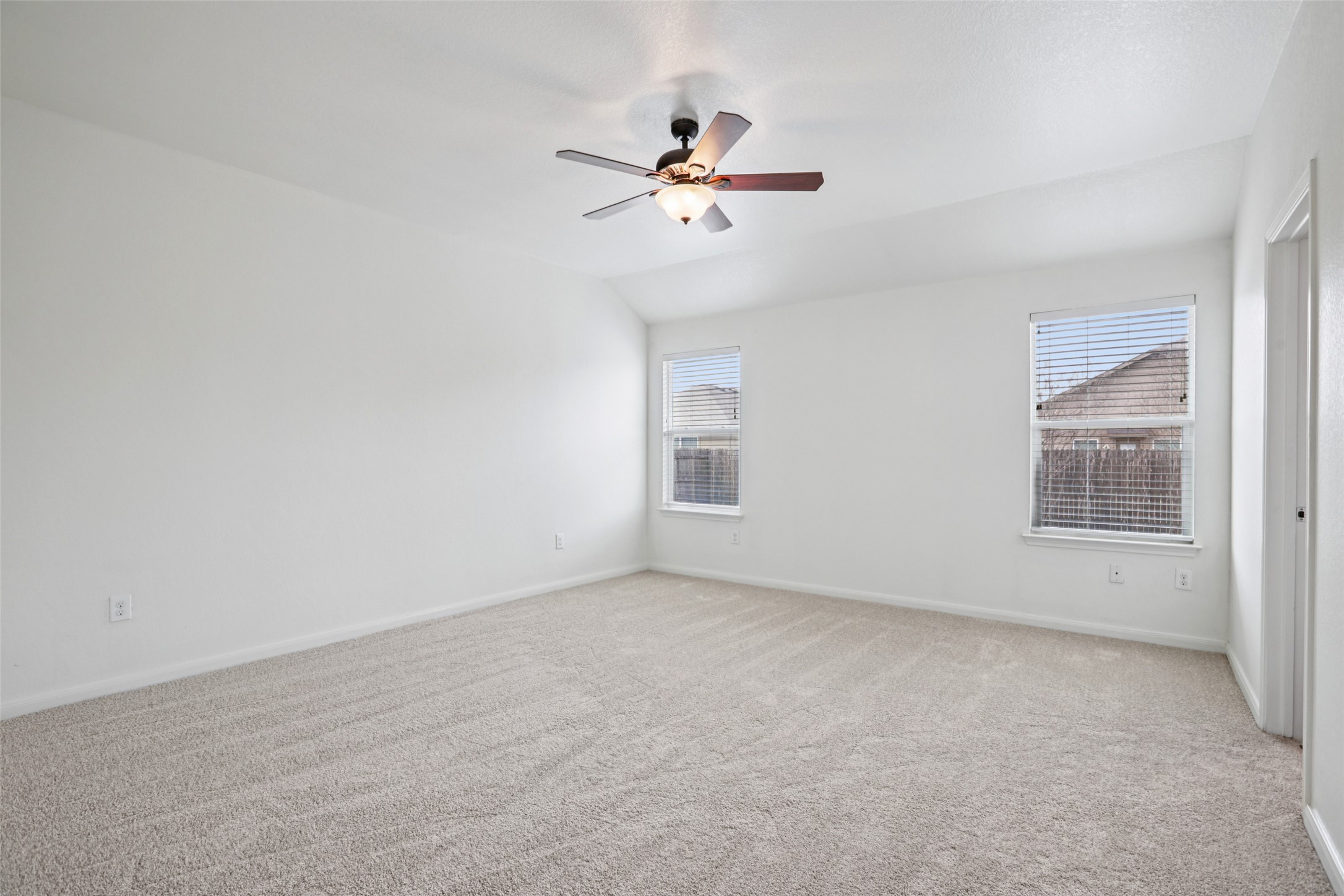 221 Alpha Kyle, TX 78640 - Photo 17 of 37 Spare room with carpet flooring, a ceiling fan, and vaulted ceiling