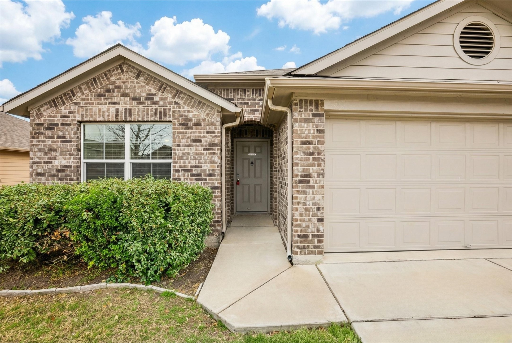 221 Alpha Kyle, TX 78640 - Photo 2 of 37 Ranch-style home featuring an attached garage, brick siding, and concrete driveway