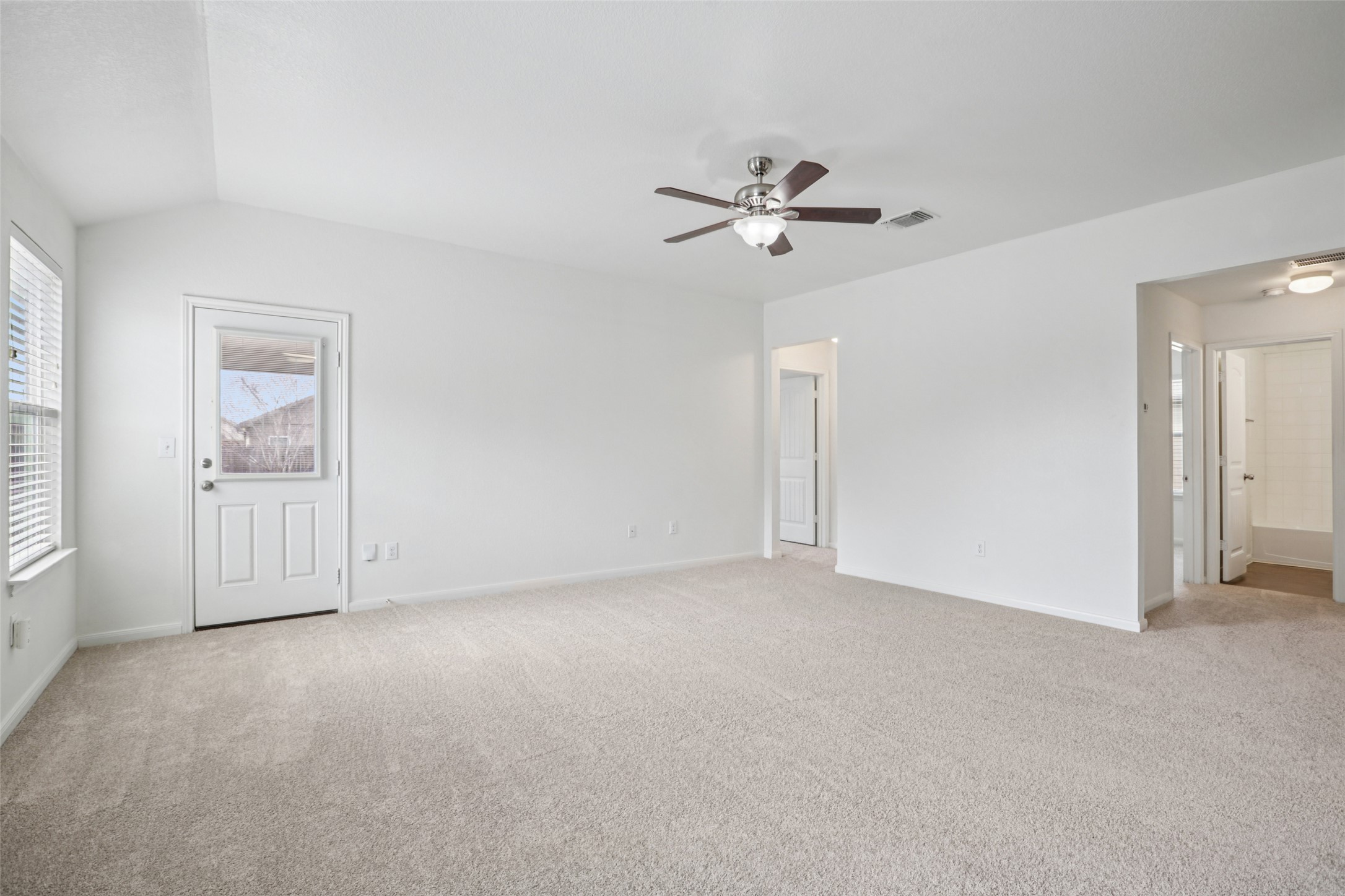 221 Alpha Kyle, TX 78640 - Photo 3 of 37 Empty room featuring ceiling fan, light colored carpet, and vaulted ceiling