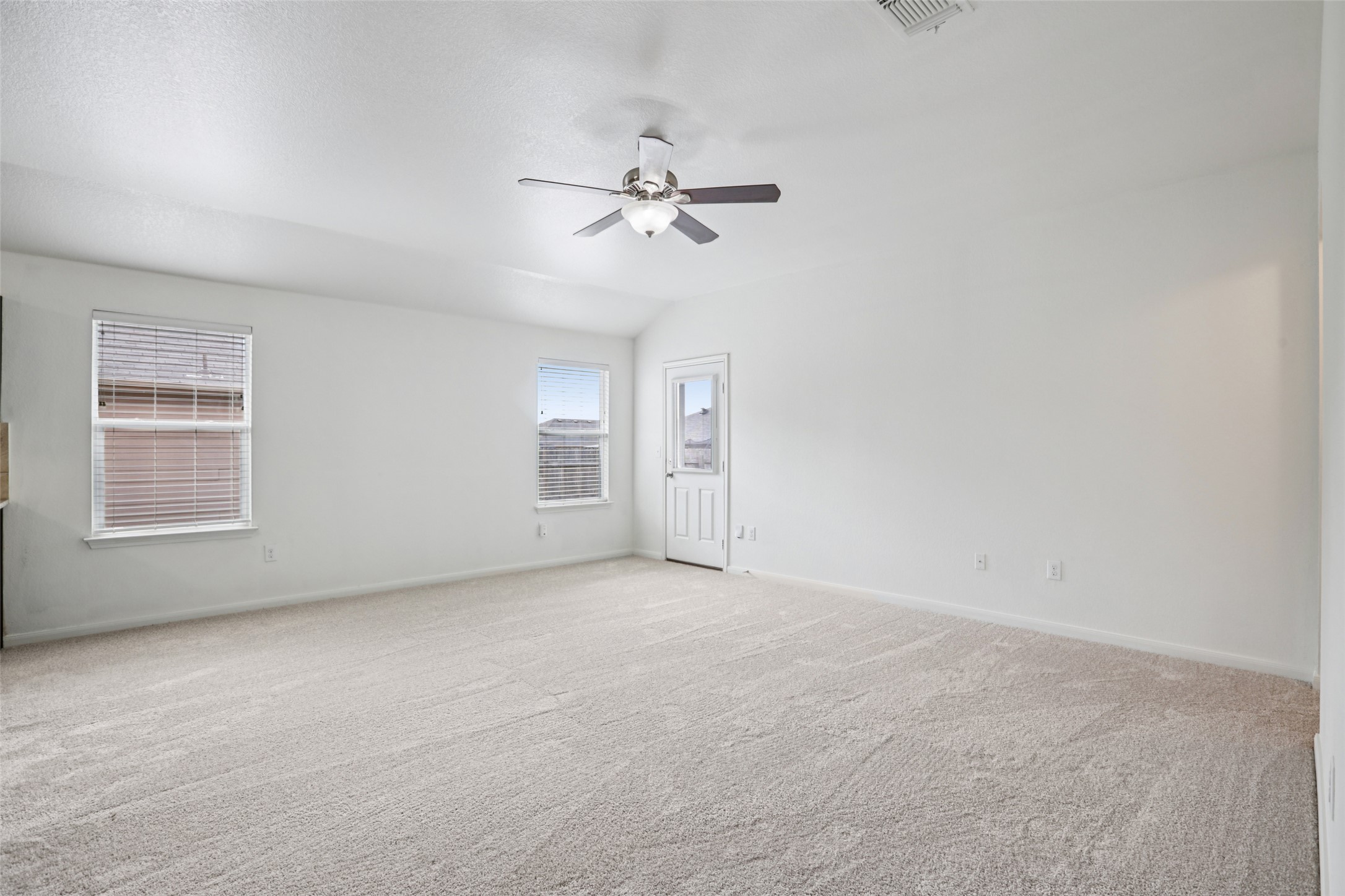 221 Alpha Kyle, TX 78640 - Photo 5 of 37 Unfurnished room featuring light carpet, ceiling fan, and lofted ceiling