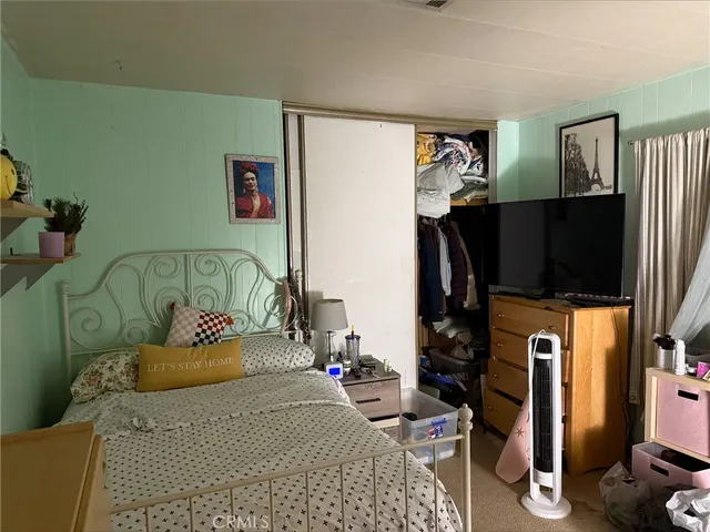 a bedroom with furniture and a flat screen tv