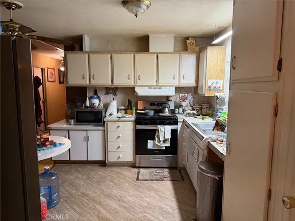 a kitchen with granite countertop a refrigerator stove top oven and sink
