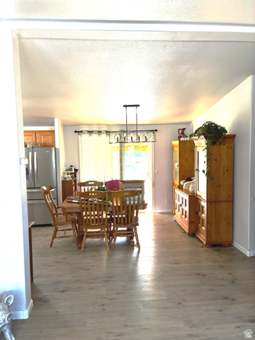 547 East 2000th Street North Vernal, UT 84078 - Photo 9 of 50 Open dining area featuring wood-finish flooring, a contemporary linear chandelier, and a sliding glass door