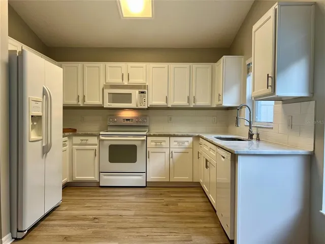 a kitchen with granite countertop a stove top oven sink and cabinets