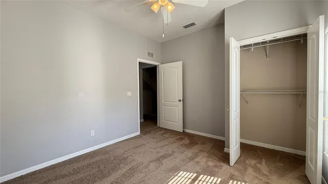 a view of an empty room with a chandelier fan