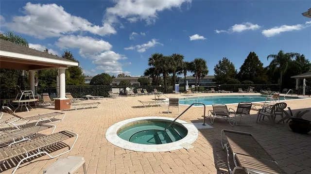 a swimming pool with outdoor seating and yard in back