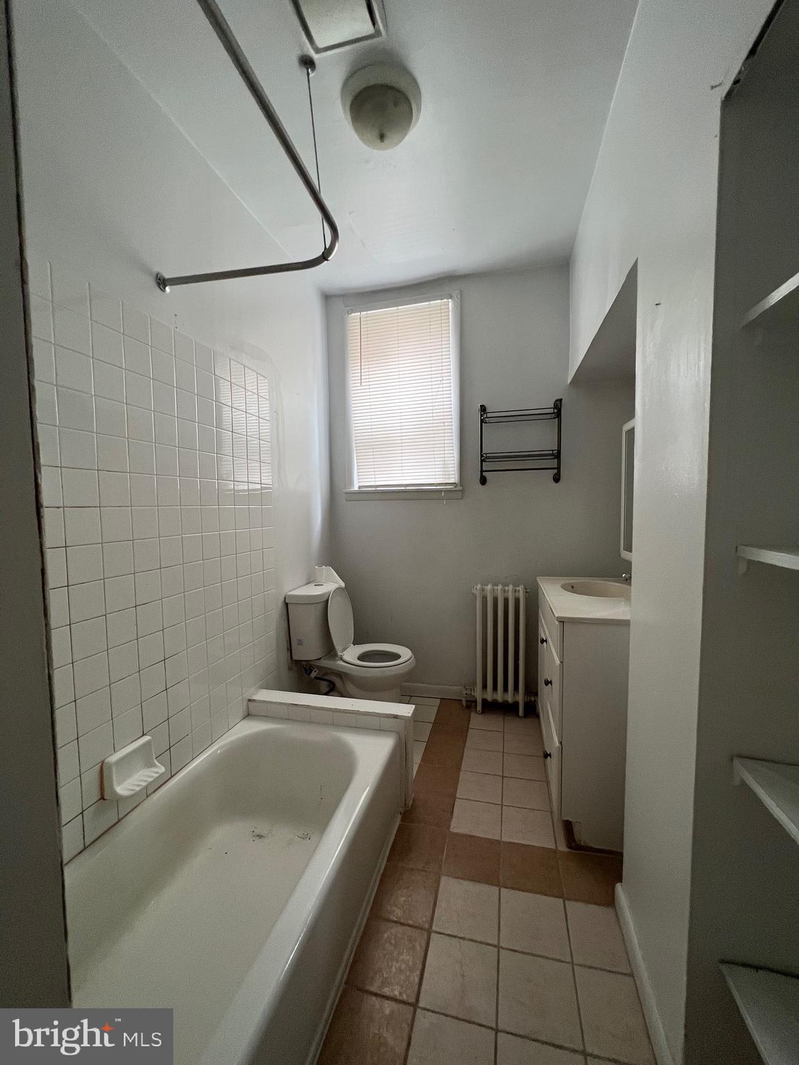 721 Bainbridge Street, Unit 2 Philadelphia, PA 19147 - Photo 5 of 8 a bathroom with a tub a sink a window and a shower