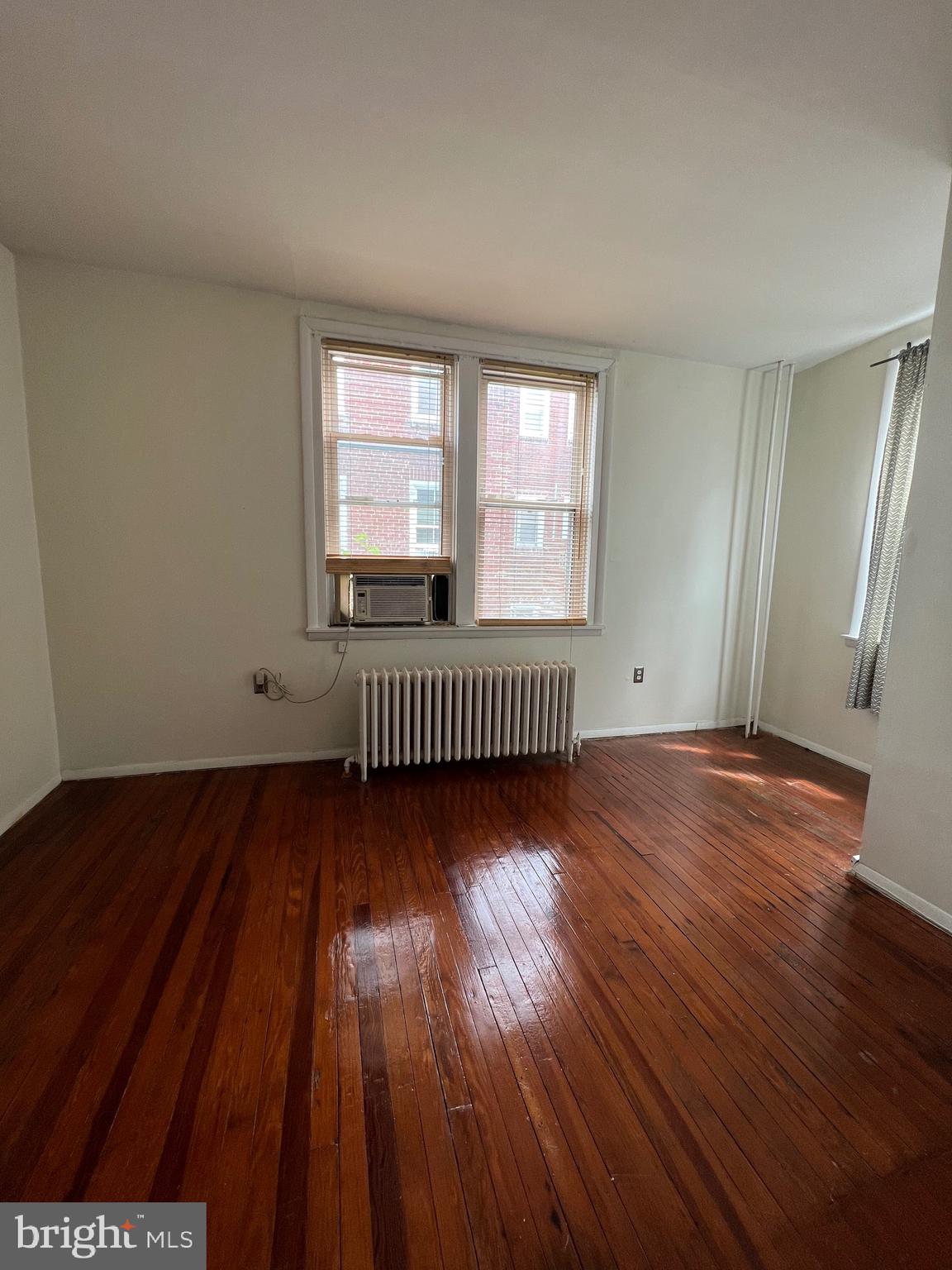 721 Bainbridge Street, Unit 2 Philadelphia, PA 19147 - Photo 6 of 8 wooden floor in an empty room with a window