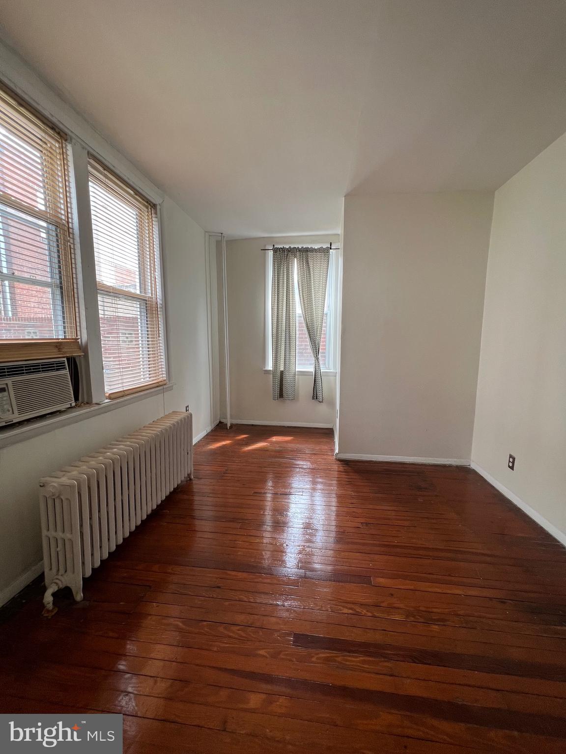 721 Bainbridge Street, Unit 2 Philadelphia, PA 19147 - Photo 7 of 8 a view of an empty room with wooden floor and a window