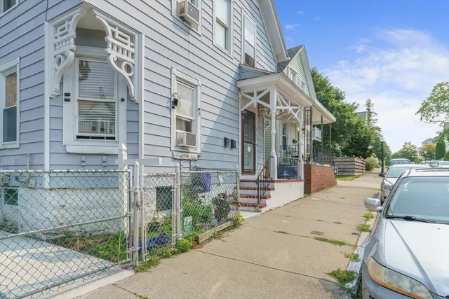 a patio with a table and chairs and potted plants