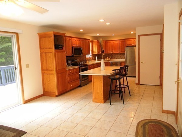 185 Athol Road Phillipston, MA 01331 - Photo 7 of 29 a kitchen with stainless steel appliances kitchen island granite countertop a refrigerator a stove a microwave oven with white cabinets and wooden floor