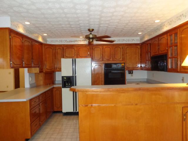 2434 Toler Road Woodlawn, TN 37191 - Photo 12 of 20 Kitchen has a tall bar separating kitchen from dining area. Oven is wall mounted so no bending over to put that large ham or turkey in the oven.