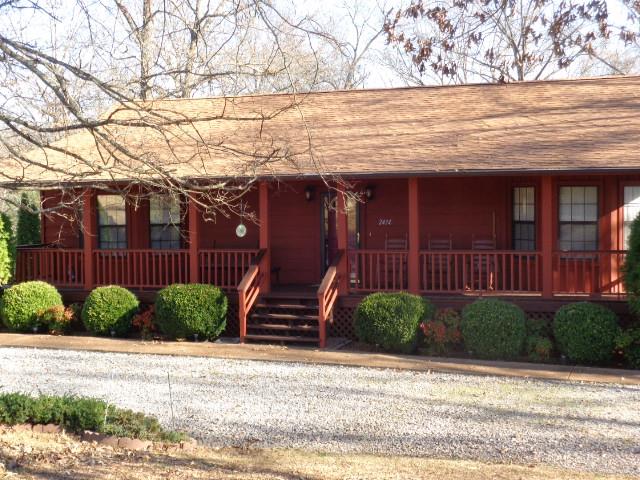 2434 Toler Road Woodlawn, TN 37191 - Photo 2 of 20 Ranch styled rustic home over unfinished basement. Home is nestled on 3.44 acres. One street into neighborhood. Long rocking chair front porch. Rocking chairs and porch swing to convey.
