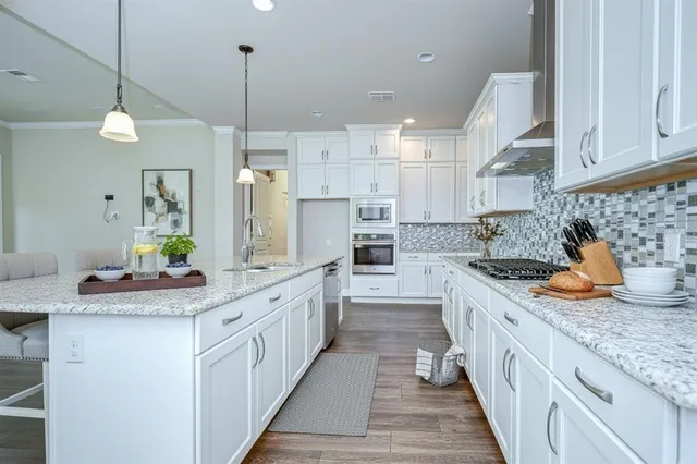 a kitchen with stainless steel appliances granite countertop a sink stove and refrigerator