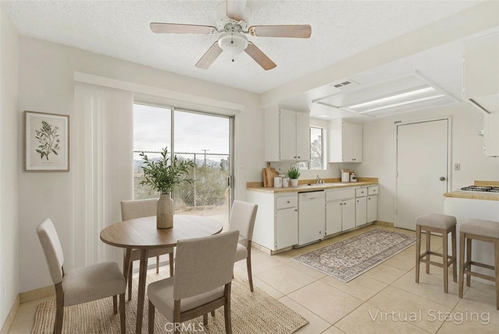 20209 Otoe Road Apple Valley, CA 92307 - Photo 13 of 32 a kitchen with a dining table chairs and white cabinets