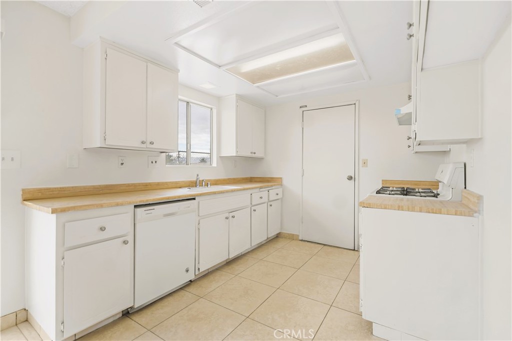 20209 Otoe Road Apple Valley, CA 92307 - Photo 21 of 32 a kitchen with cabinets and white appliances