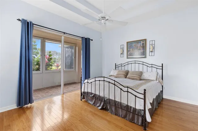 a bedroom with a bed and a large window with wooden floor