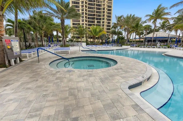 a view of swimming pool with outdoor seating and house in the background