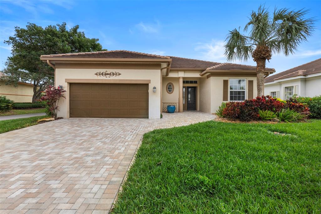 11 Winghaven Lane Fort Pierce, FL 34949 - Photo 48 of 50 a front view of a house with garden and garage