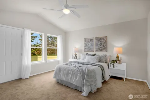 a bedroom with a bed lamp and a large window