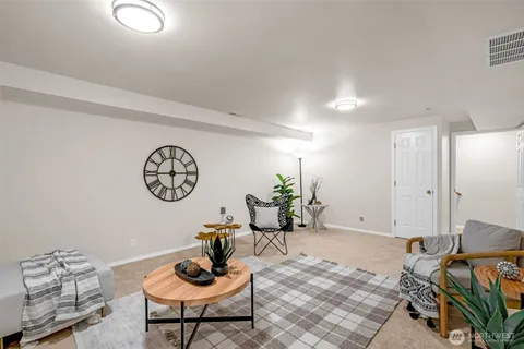 a living room with furniture a rug and a wall painting