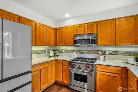 a kitchen with stainless steel appliances granite countertop a stove a sink and a microwave