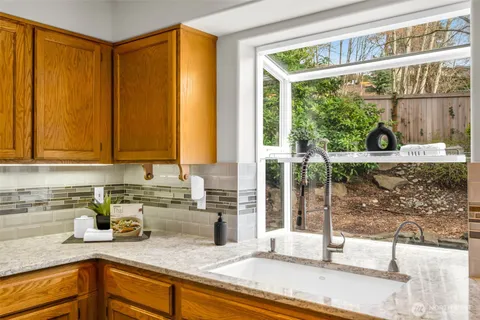 a kitchen with stainless steel appliances granite countertop a sink and a window