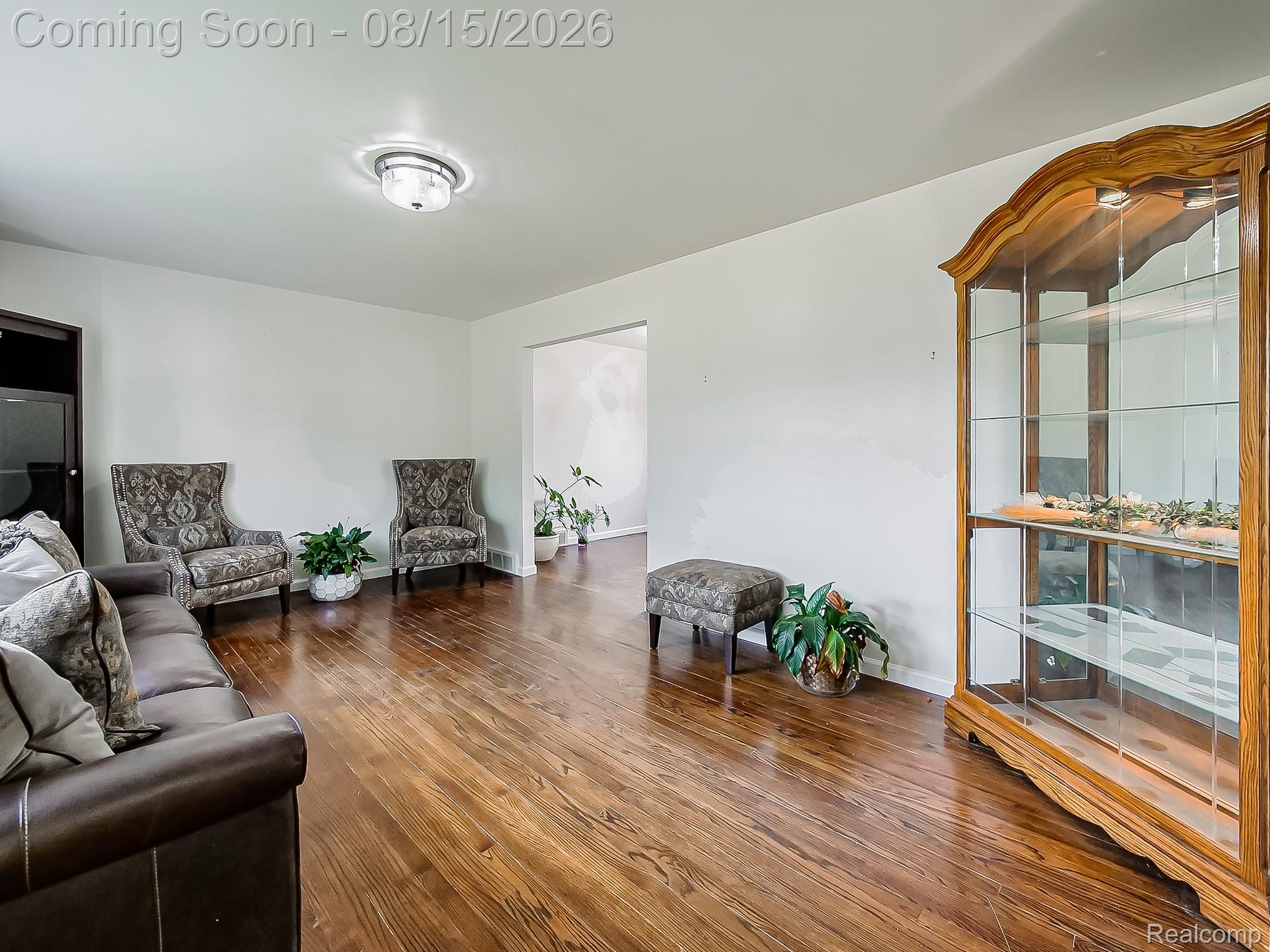 21131 Harvard Road Southfield, MI 48076 - Photo 2 of 33 Spacious living area showcasing rich wood-finish flooring throughout, complemented by white walls and recessed ceiling lighting