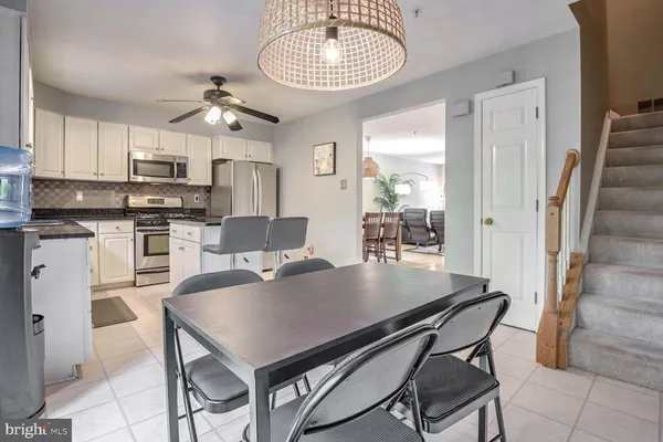 a kitchen with stainless steel appliances granite countertop a stove refrigerator a microwave oven with a dining table and chairs