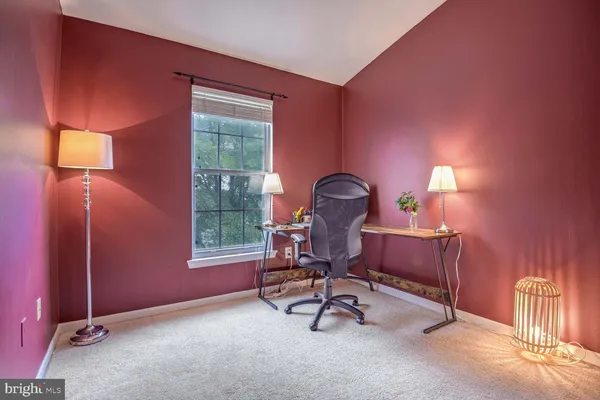 a view of a workspace with furniture and a window
