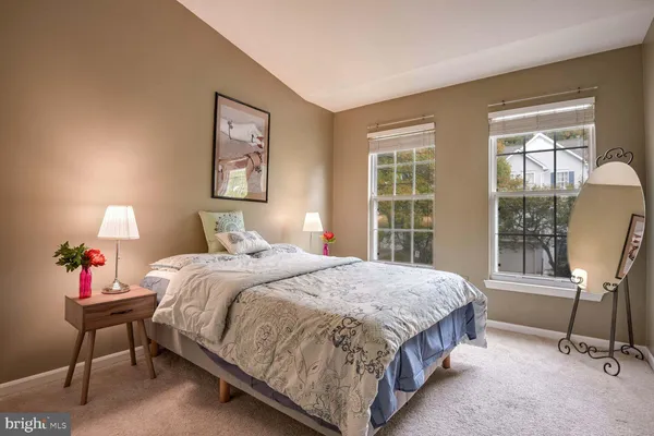 a bedroom with a bed a chair and a large window