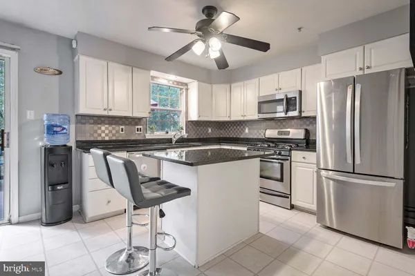a kitchen with stainless steel appliances a refrigerator a stove a sink and a refrigerator