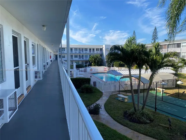 a view of a porch and patio with table & chairs & potted plants