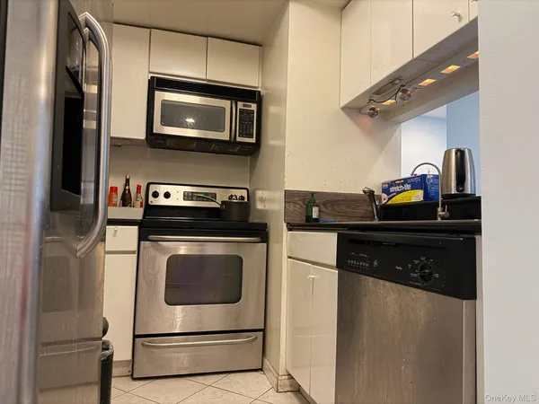 a kitchen with stainless steel appliances granite countertop a stove microwave and refrigerator