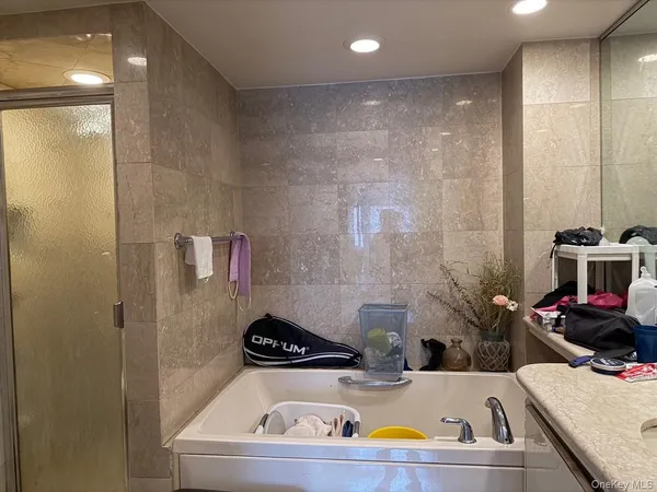 a bathroom with a tub sink and mirror