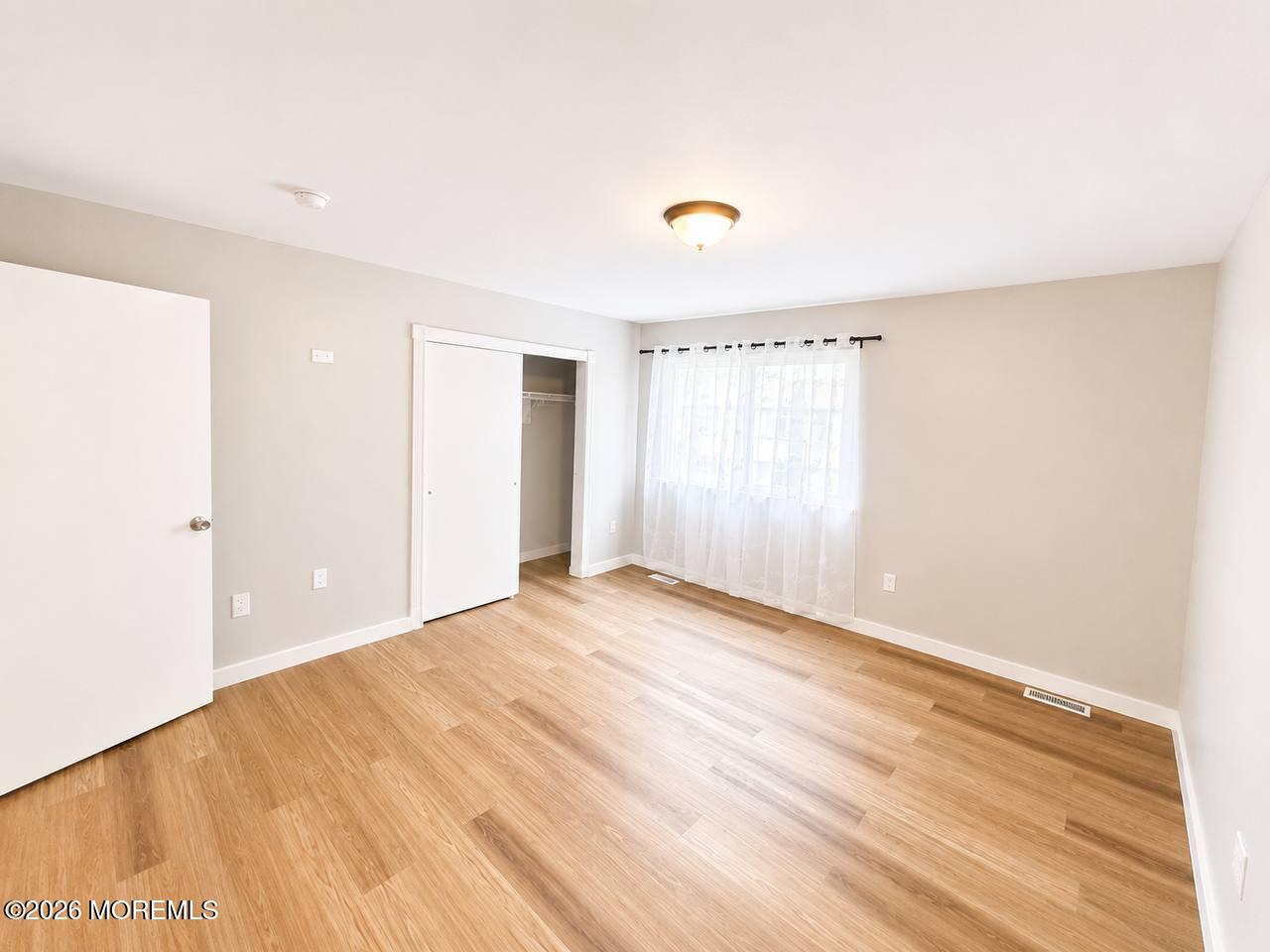 1144 Sawmill Road, Unit 121 Brick, NJ 08724 - Photo 13 of 23 a view of an empty room with wooden floor