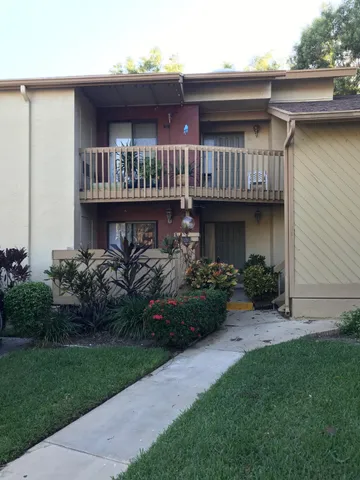 a view of backyard with potted plants and wooden fence