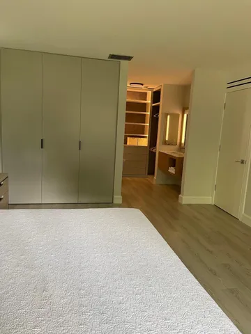 a view of empty room with wooden floor and closet