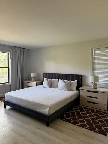 a bedroom with a bed and windows