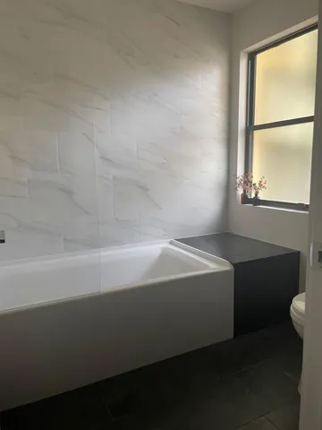 a spacious bathroom with a bathtub and a window