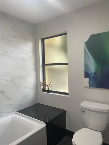 a bathroom with a toilet a sink and mirror