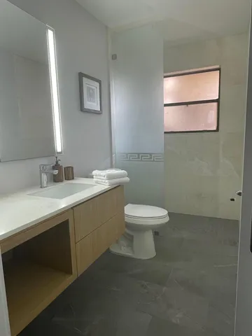 a bathroom with a toilet sink and mirror