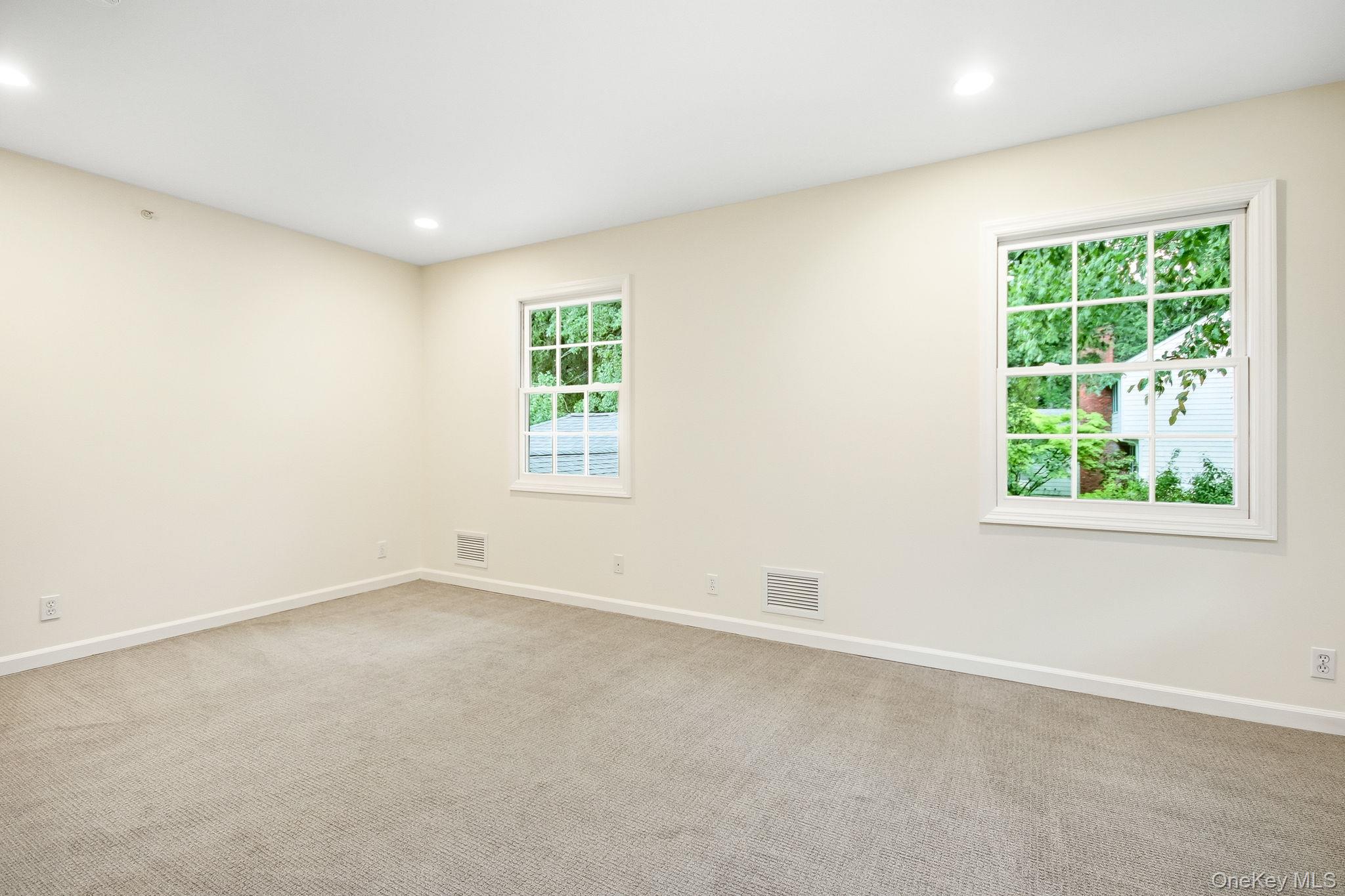 26 Century Ridge Road Purchase, NY 10577 - Photo 20 of 50 Second en-suite bedroom featuring two windows with white trim, recessed lighting, neutral wall paint, and beige carpeting