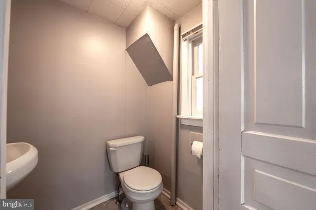 a white toilet sitting next to a window