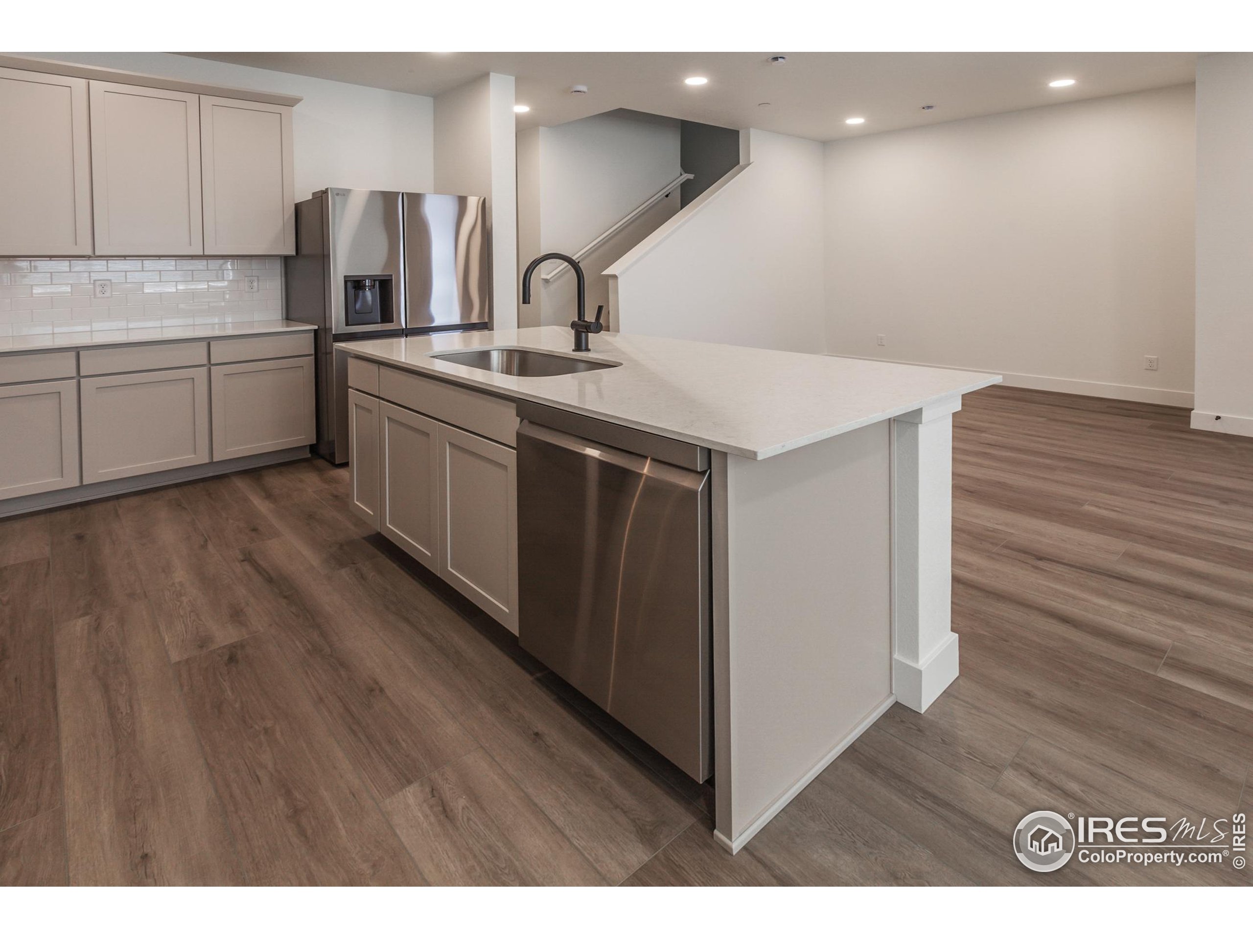 4909 Autumn Leaf Drive Timnath, CO 80547 - Photo 11 of 34 a kitchen with stainless steel appliances granite countertop a sink a stove a refrigerator and island with wooden floor