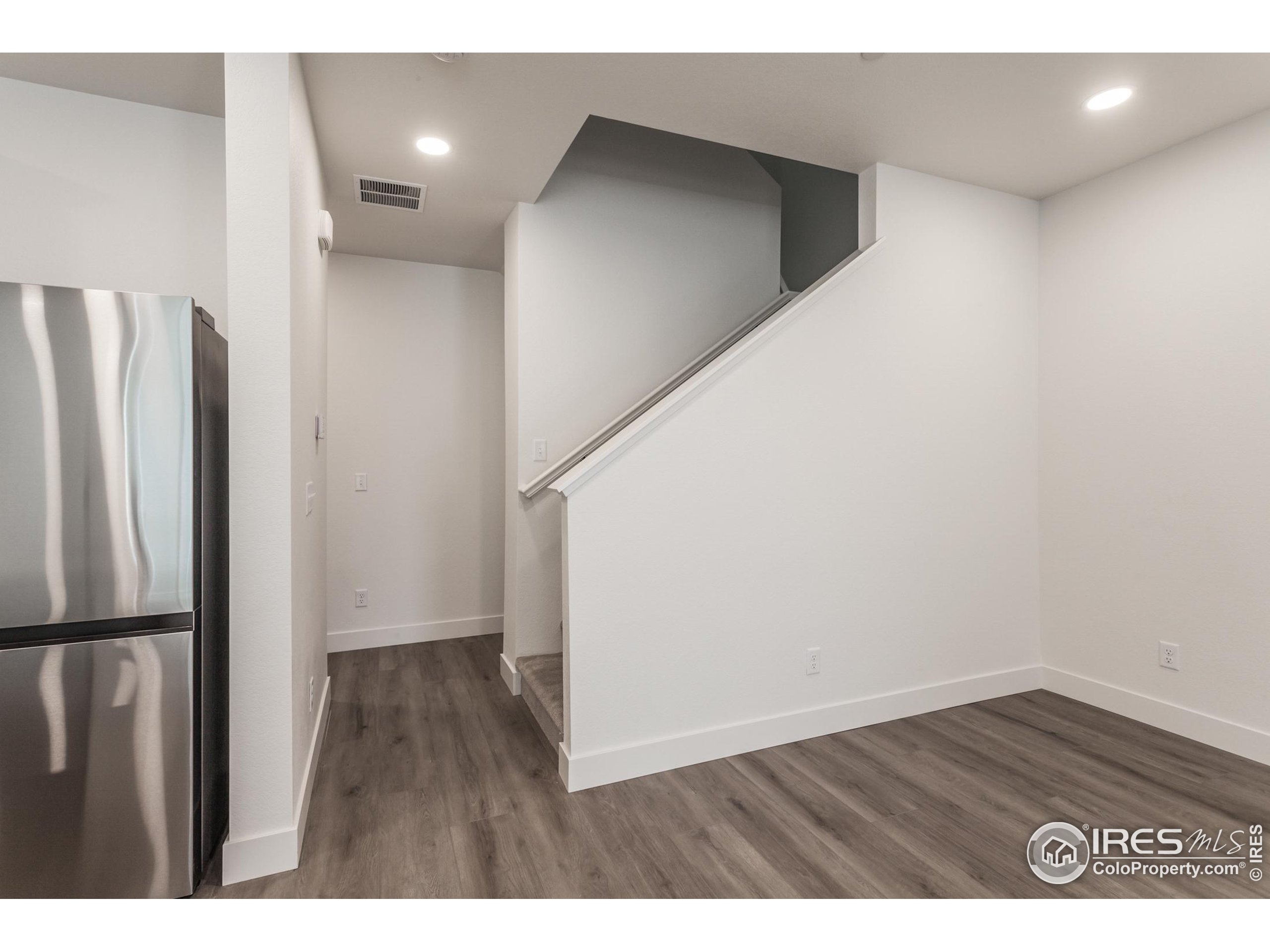 4909 Autumn Leaf Drive Timnath, CO 80547 - Photo 15 of 34 a view of an empty room with wooden floor and a cabinet