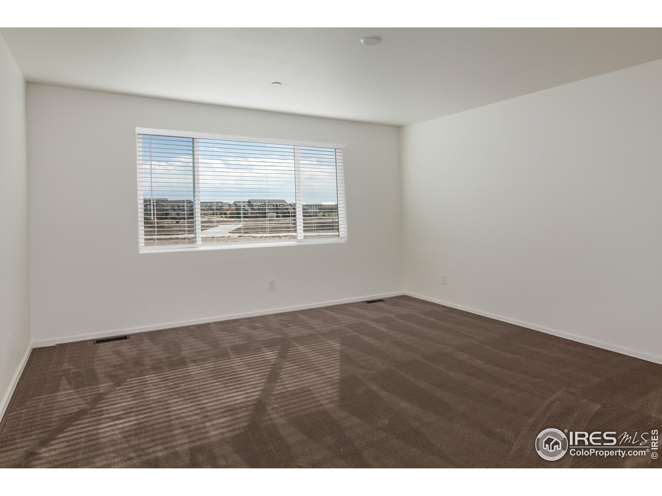 4909 Autumn Leaf Drive Timnath, CO 80547 - Photo 29 of 34 a view of an empty room with wooden floor and a window