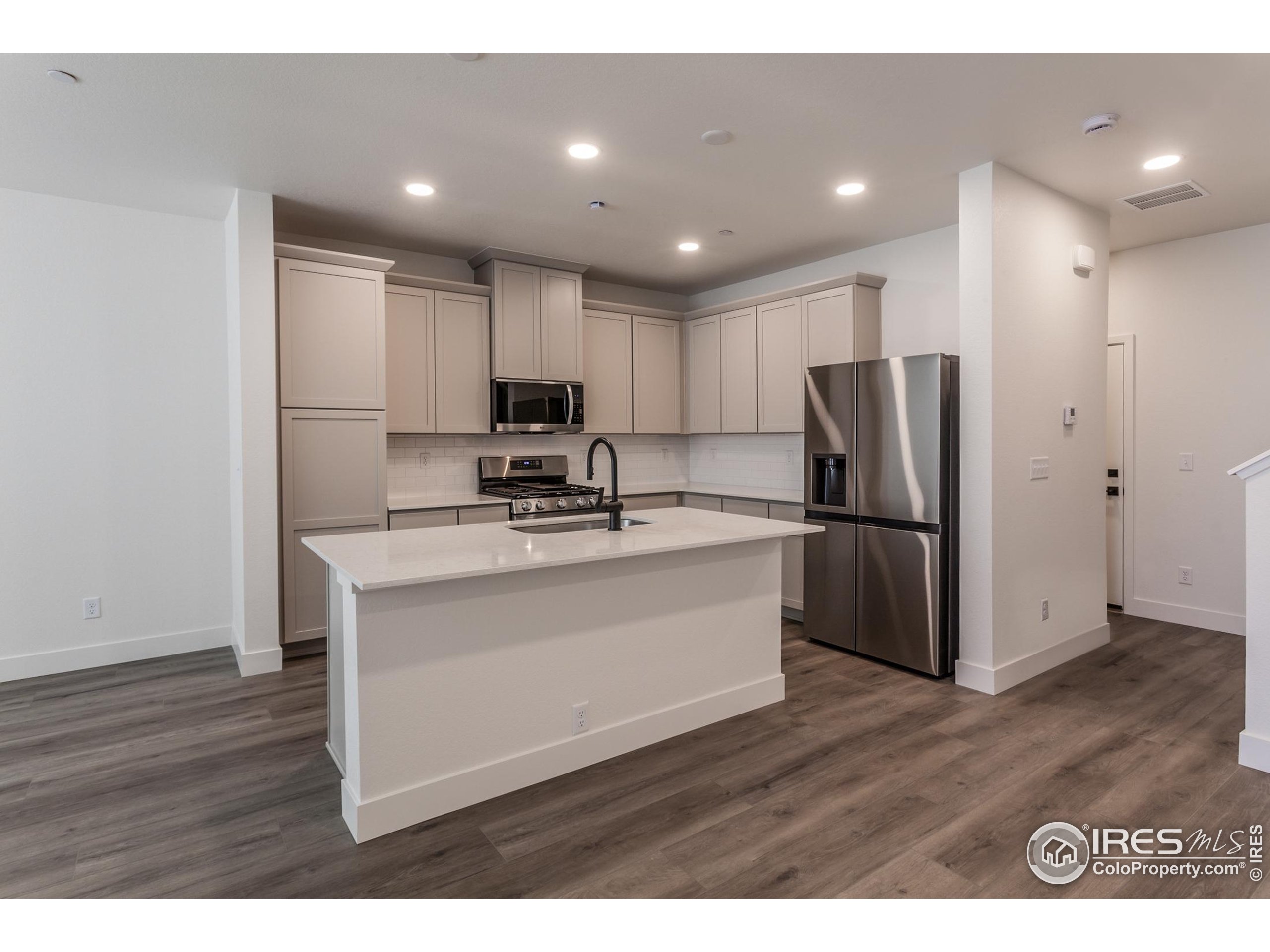 4909 Autumn Leaf Drive Timnath, CO 80547 - Photo 7 of 34 a kitchen with kitchen island a refrigerator sink and cabinets