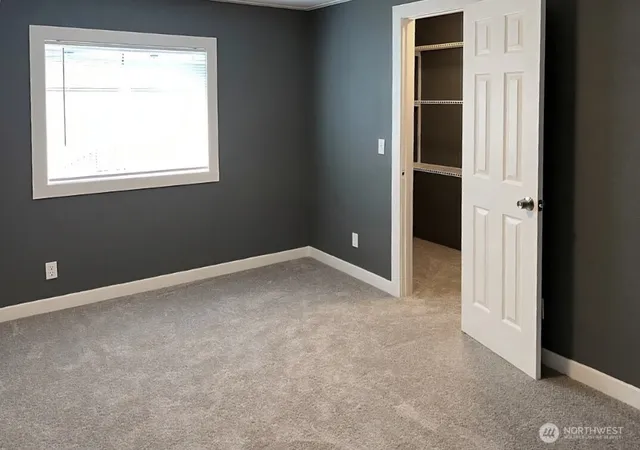 an empty room with windows and closet