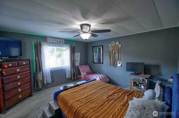 a bedroom with a bed and a flat screen tv